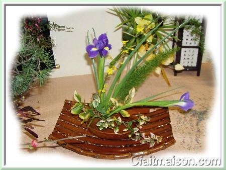 Composition dans un plat  four pos dans une corbeille asiatique en bambou avec pique-fleurs en fer, iris et fusain panach.